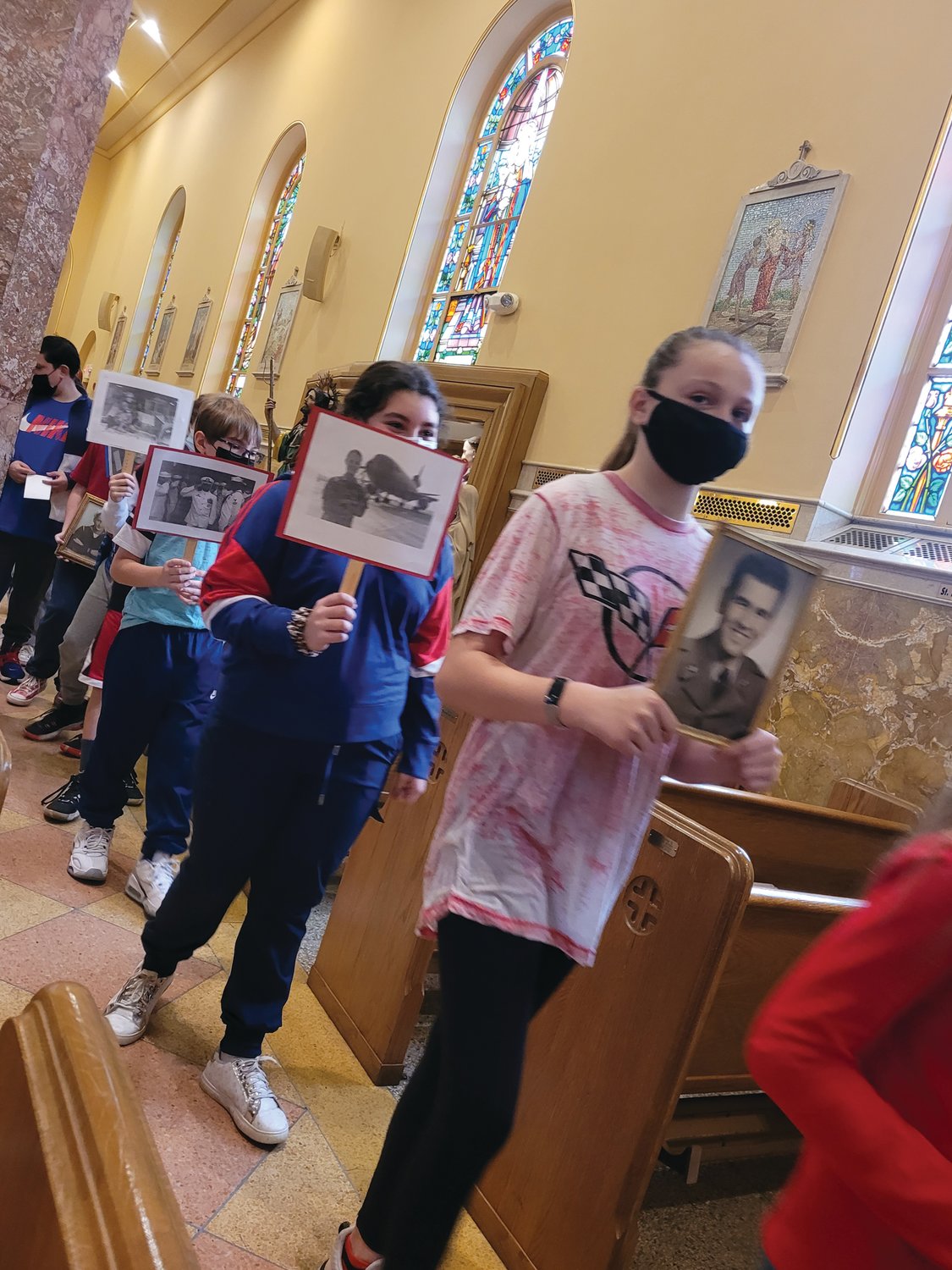 The students of St. Rocco School in Johnston walked down the church isles holding photographs of veterans they loved. The school held a prayer service for veterans on Wednesday morning at St. Rocco Church.